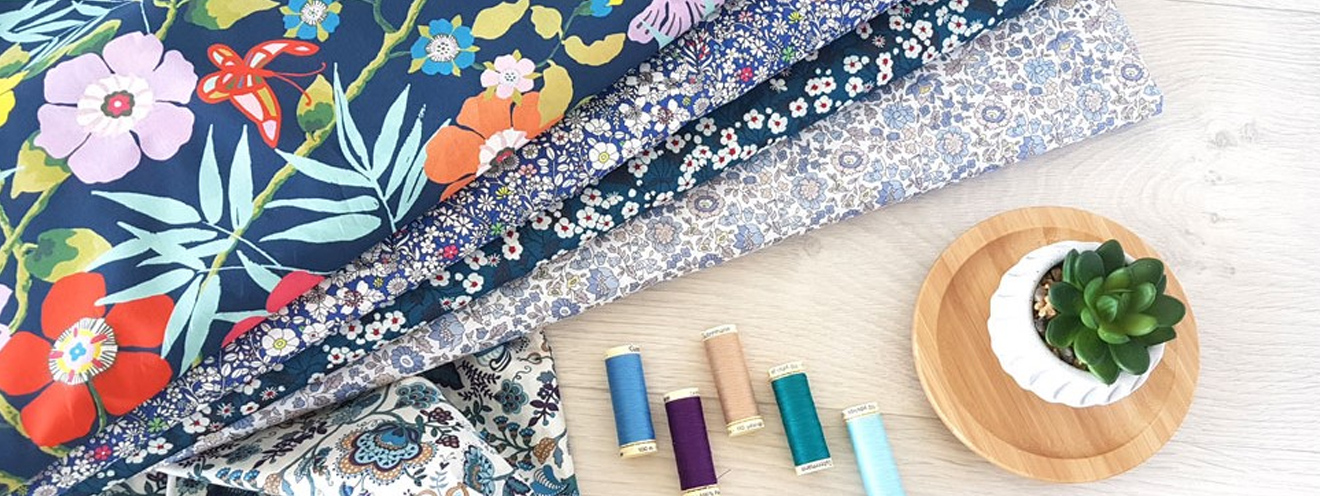 Des étagères de rouleaux de tissus avec une très grande collection de tissus Liberty, avec beaucoup de choix de dessins et de couleurs