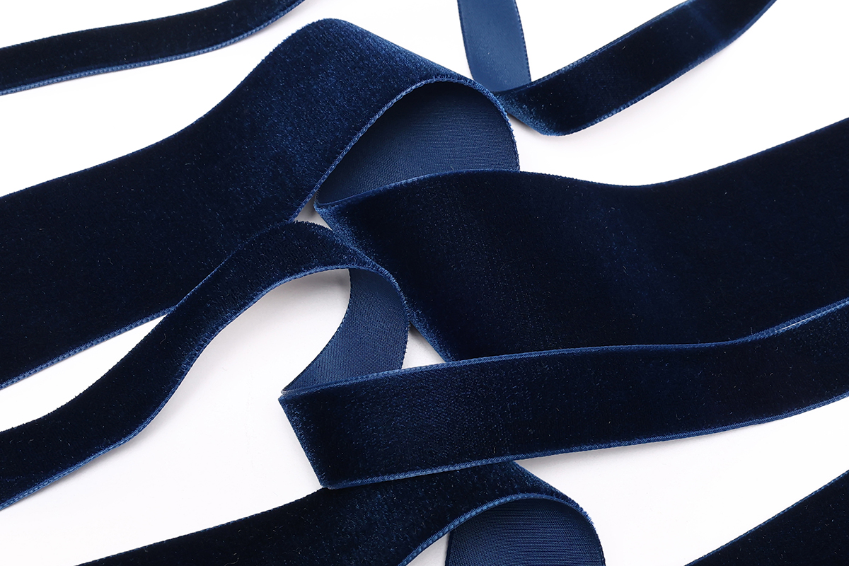 Gros plan sur des rubans velours marine, nous pouvons voir le côté doux et brillant de chaque ruban.