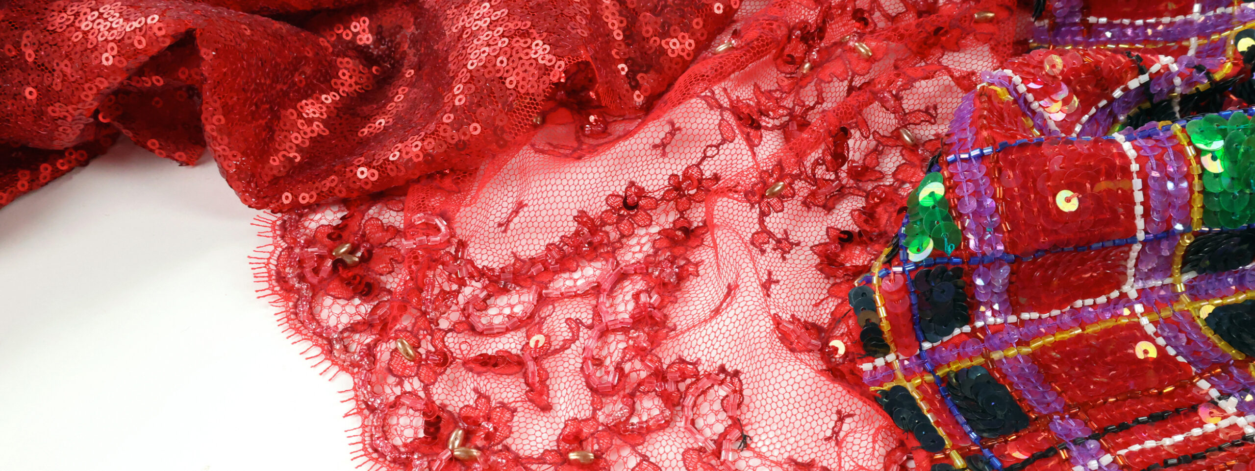 Présentation d'un tissu à paillettes et d'un tissu avec des perles pour la haute couture disponibles chez Stragier