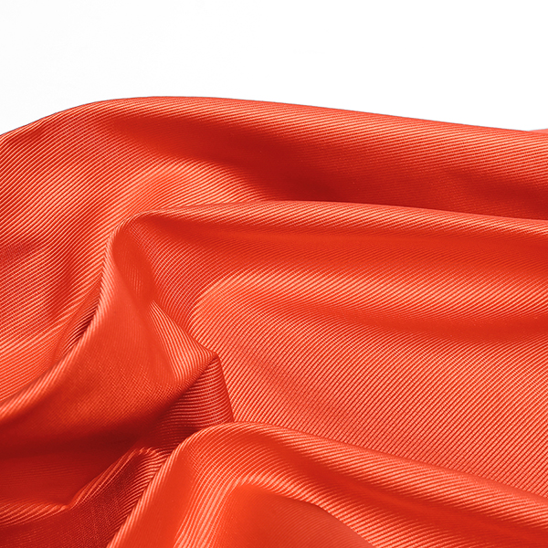 Présentation d'un tissu orange en matière Ottoman disponible chez Stragier